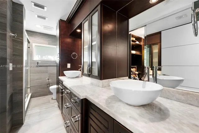 a spacious bathroom with a double vanity sink mirror and shower