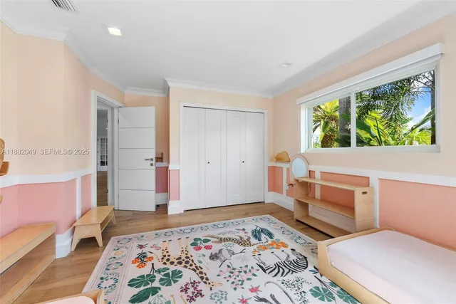 a bedroom with a bed and a dresser next to a window