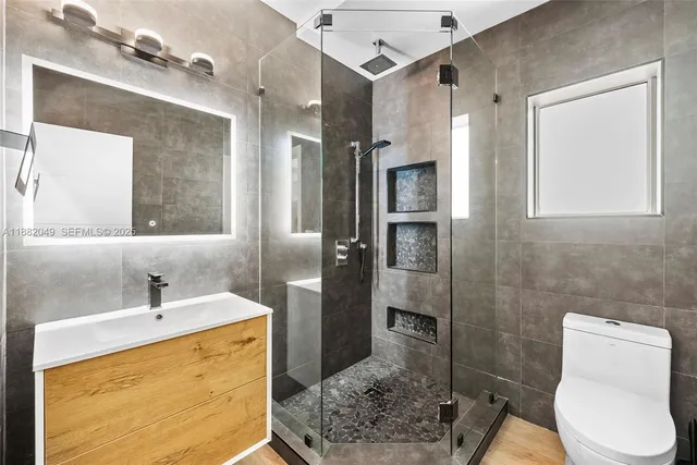 a bathroom with a sink a toilet and shower
