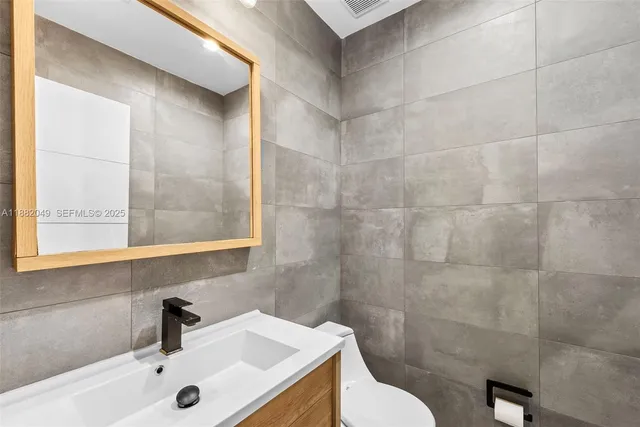 a bathroom with a sink a toilet and a mirror