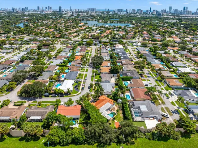 an aerial view of residential houses with outdoor space and trees