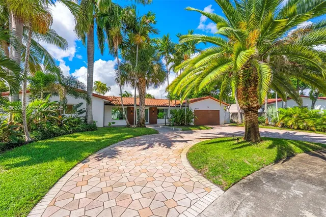 a view of a house with swimming pool and a large tree
