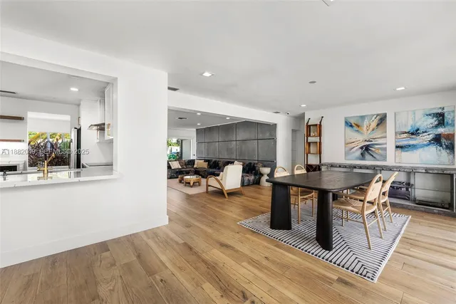 a living room with furniture a table and kitchen view
