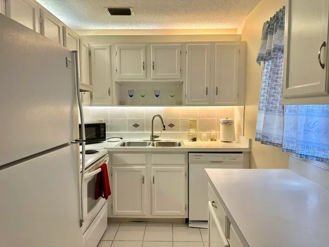 a kitchen with a sink a stove and cabinets