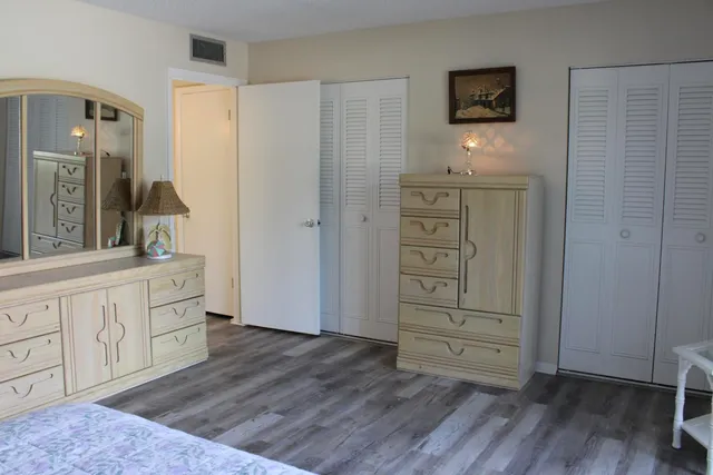 a room with white cabinets and wooden floor