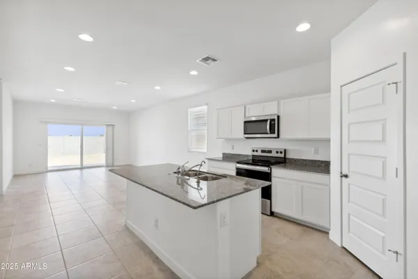 a kitchen with a sink stove and white cabinets