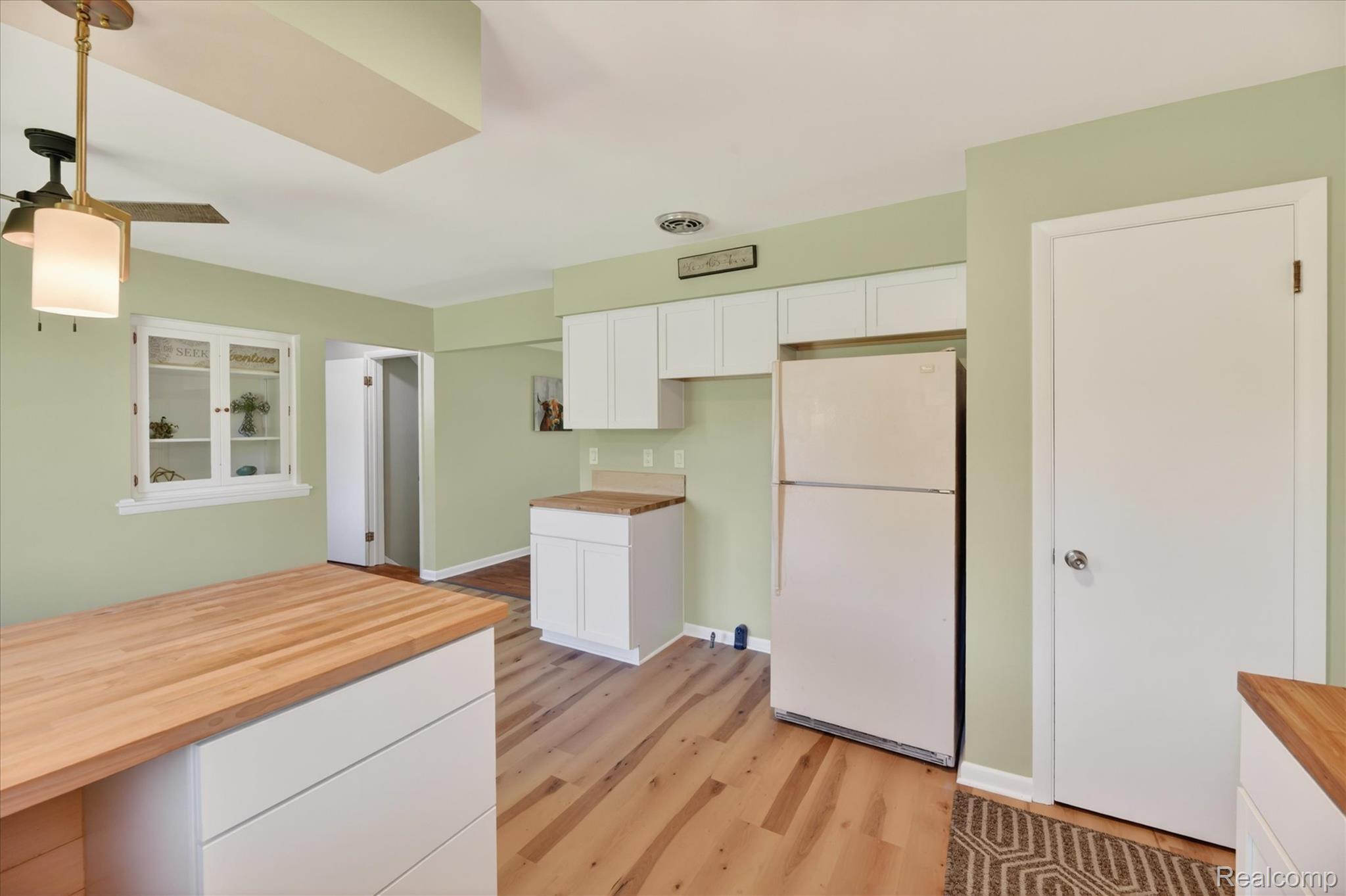 2250 Montague Road Davison, MI 48423 - Photo 15 of 45 Kitchen featuring light wood-finish flooring, white cabinetry, butcher block countertops, and a built-in display cabinet