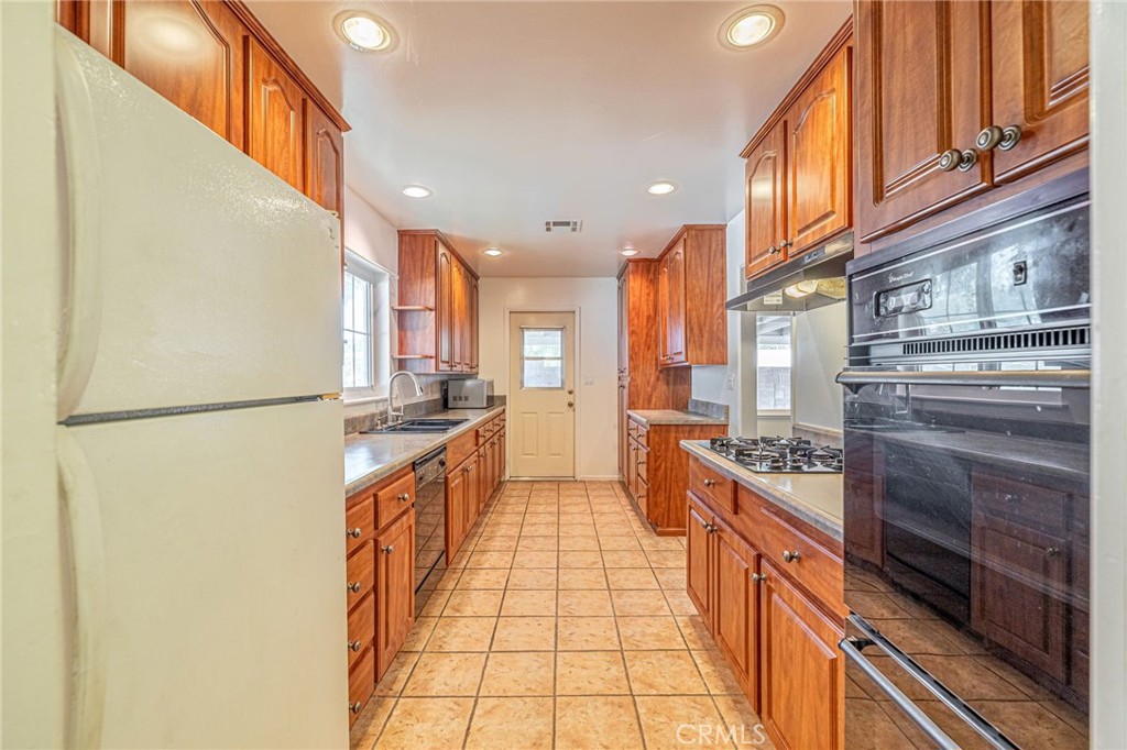 44916 18th Street West Lancaster, CA 93534 - Photo 12 of 32 a kitchen with stainless steel appliances granite countertop a refrigerator a stove and a sink