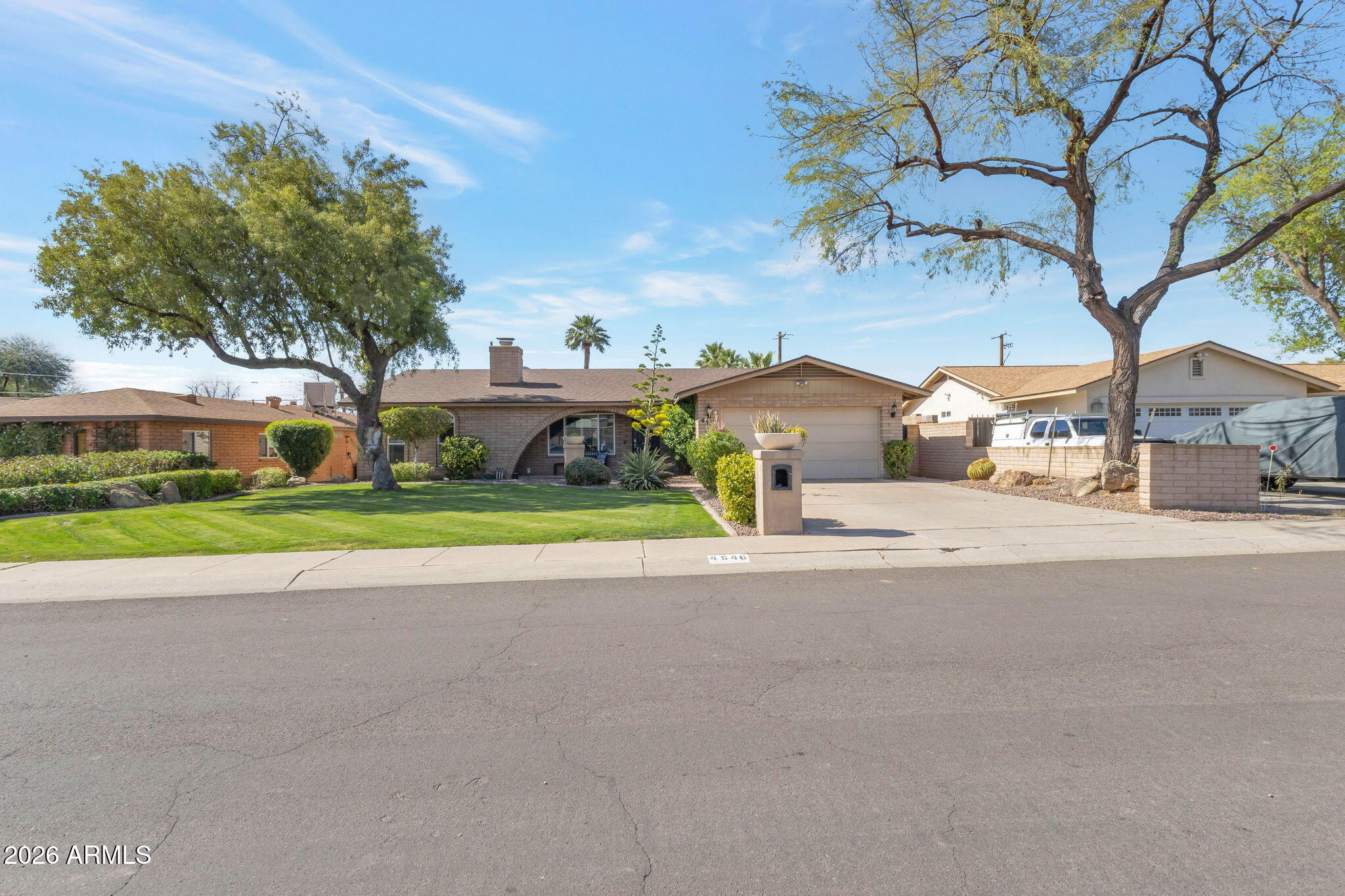 4546 North 34th Place Phoenix, AZ 85018 - Photo 2 of 29 a view of a house with a big yard and large trees
