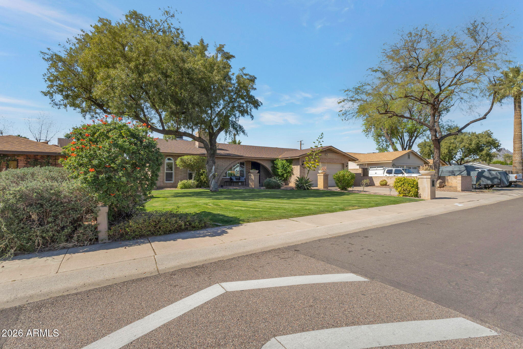 4546 North 34th Place Phoenix, AZ 85018 - Photo 4 of 29 a view of a white house with a big yard and large trees