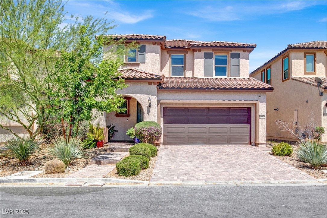 10976 Bluebell Basin Road Las Vegas, NV 89179 - Photo 1 of 40 Mediterranean / spanish-style house with a tile roof, an attached garage, decorative driveway, and stucco siding