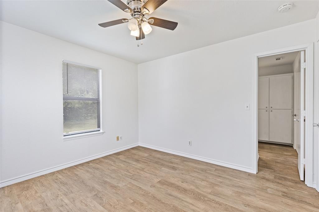 420 South Riggins Street Anna, TX 75409 - Photo 11 of 25 an empty room with wooden floor a ceiling fan and windows