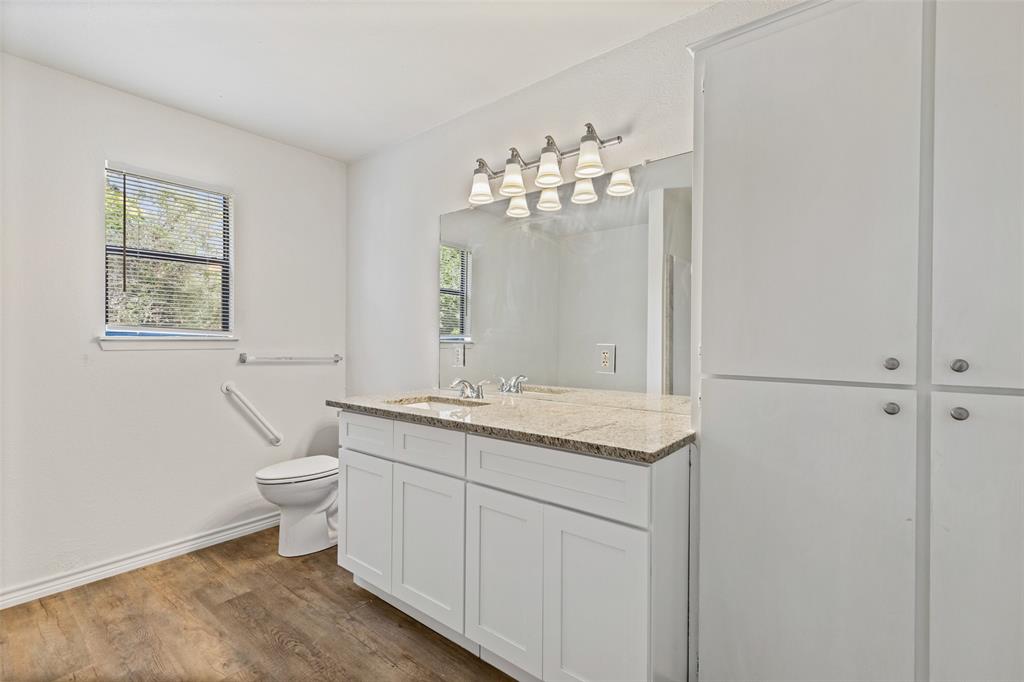 420 South Riggins Street Anna, TX 75409 - Photo 12 of 25 a bathroom with a granite countertop toilet a sink and a mirror