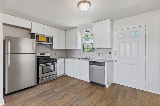 a kitchen with a refrigerator and a stove top oven