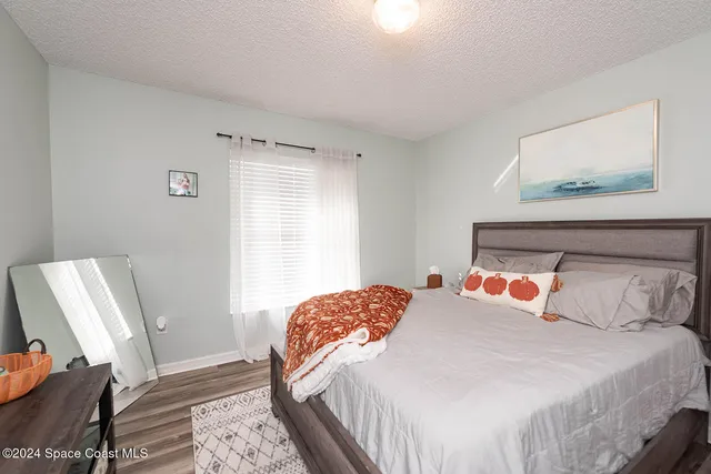 a bedroom with a bed and wooden floor