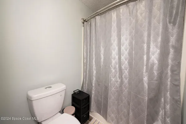 a bathroom with a toilet and a shower curtain