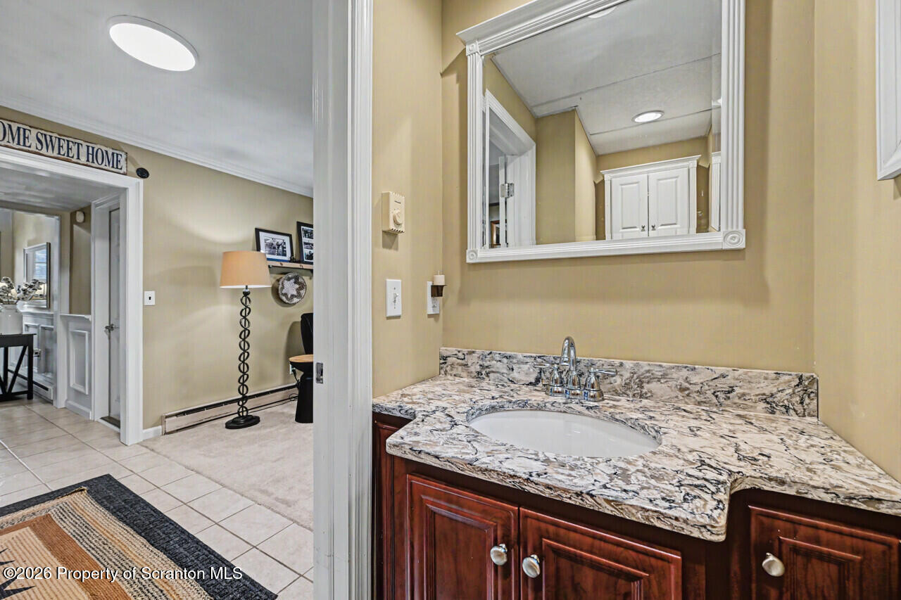 121 T Rt 351 Moscow, PA 18444 - Photo 34 of 79 a bathroom with a granite countertop sink and a mirror