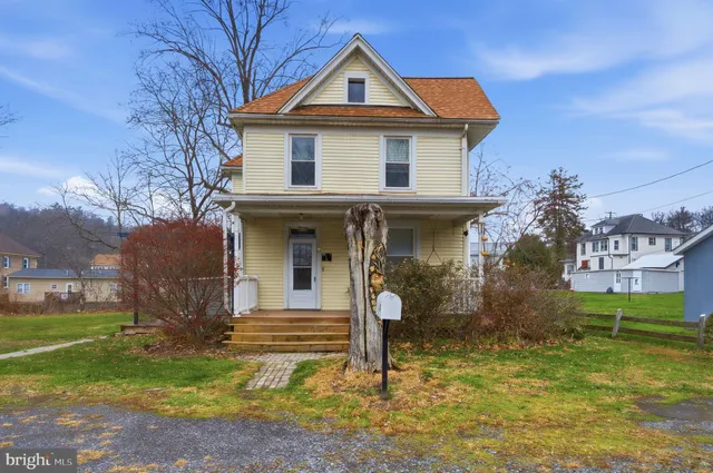 a view of a house with backyard and trees