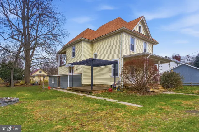 a view of a house with backyard and a tree