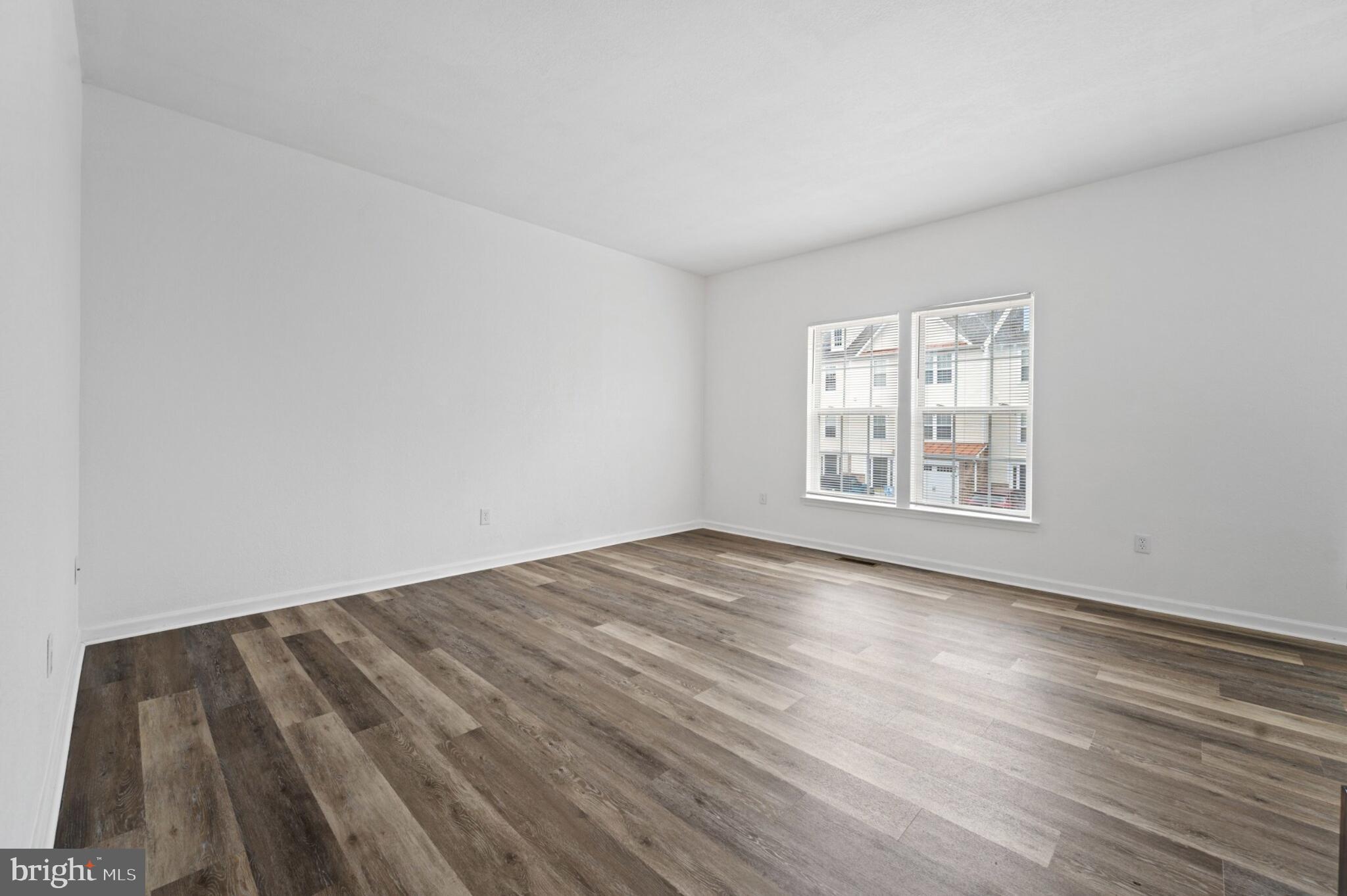 29 Pier Point Drive Millville, DE 19967 - Photo 16 of 36 an empty room with wooden floor cabinet and windows