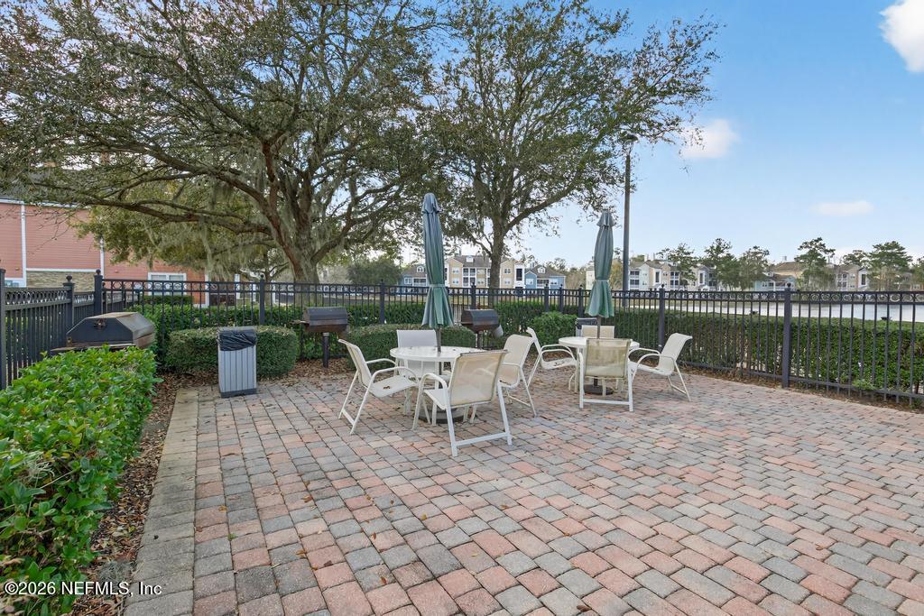 8550 Touchton Road, Unit 2221 Jacksonville, FL 32216 - Photo 49 of 53 a view of a patio with table and chairs potted plants and large tree