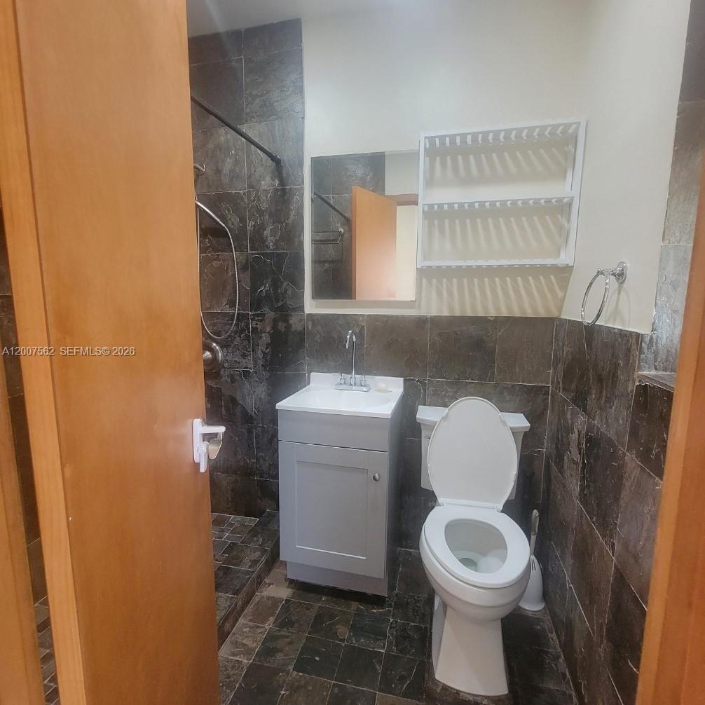 7400 Harding Avenue, Unit 15 Miami Beach, FL 33141 - Photo 20 of 26 a bathroom with a toilet a sink and a mirror