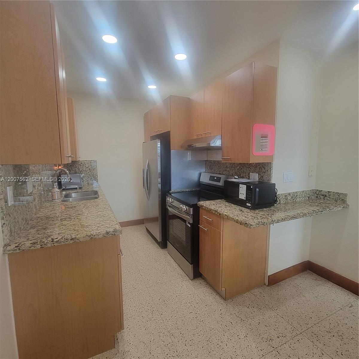 7400 Harding Avenue, Unit 15 Miami Beach, FL 33141 - Photo 2 of 26 a kitchen with stainless steel appliances granite countertop a sink stove and refrigerator