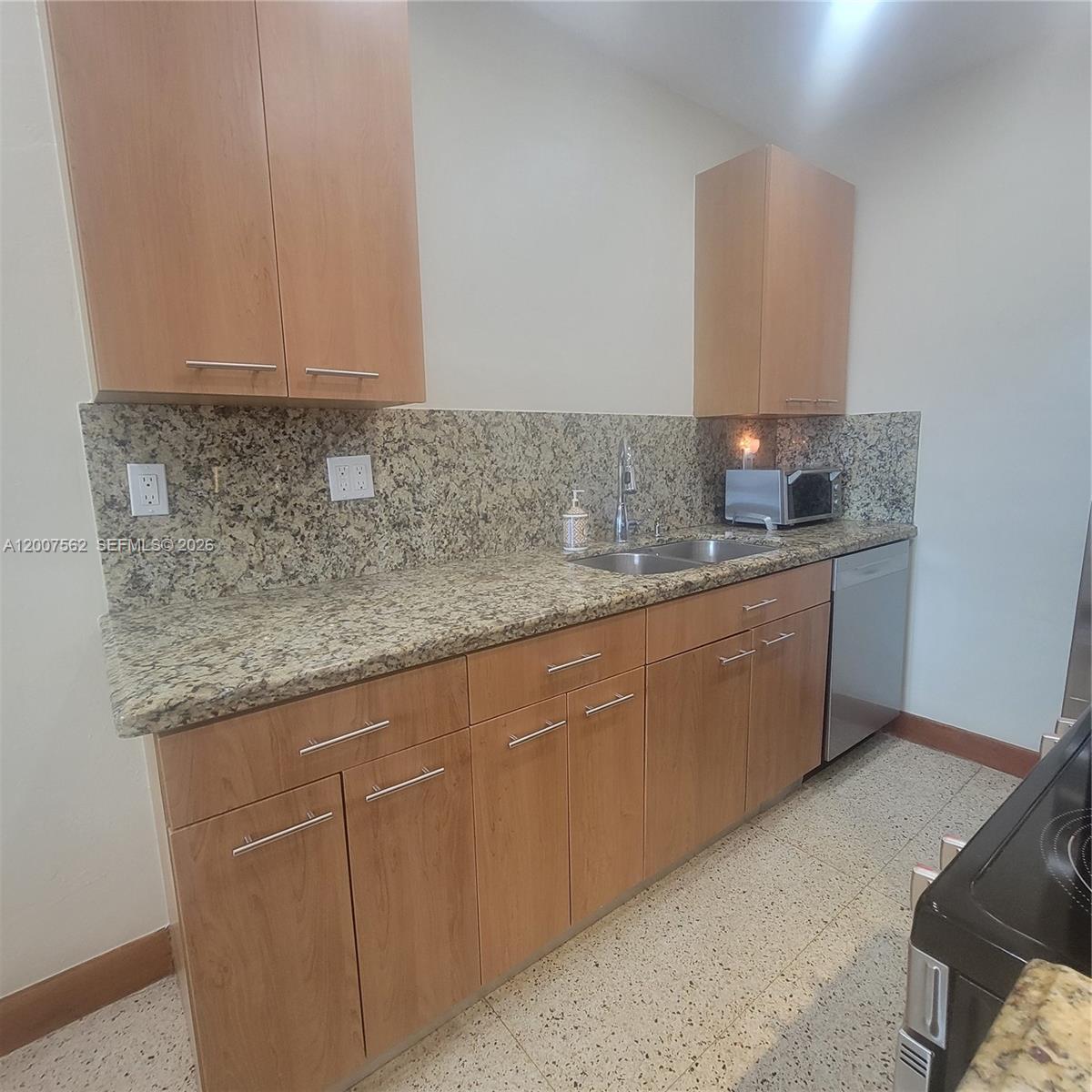 7400 Harding Avenue, Unit 15 Miami Beach, FL 33141 - Photo 4 of 26 a kitchen with stainless steel appliances granite countertop a sink and cabinets