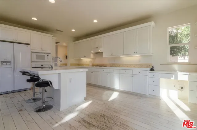 a kitchen with a sink cabinets and wooden floor