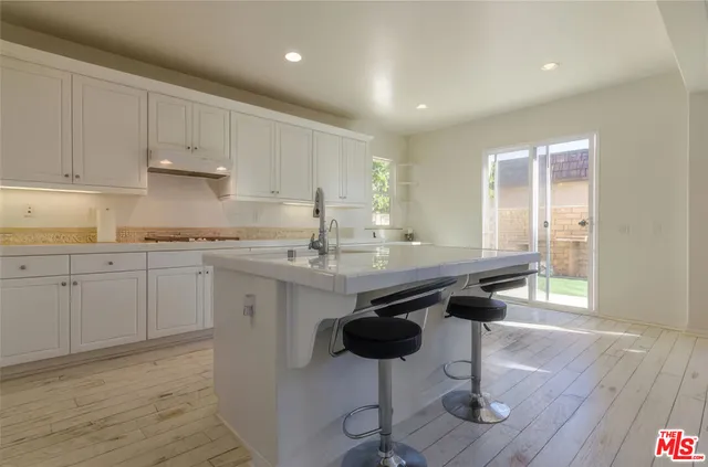 a kitchen with a sink cabinets and wooden floor