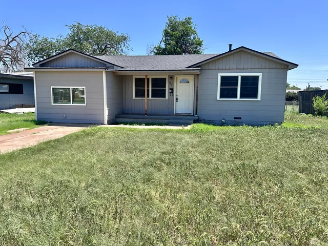 a front view of a house with yard and green space