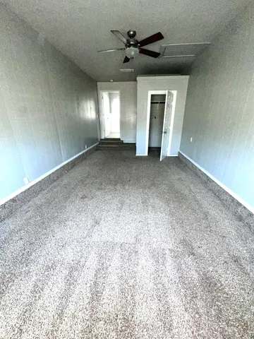 a view of a livingroom with a ceiling fan and window