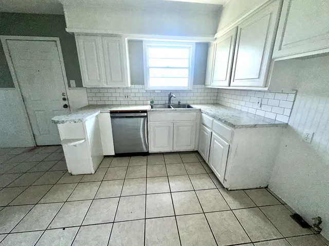 a kitchen with a sink a stove top oven and cabinets