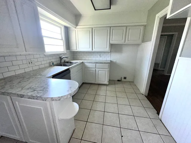 a kitchen with a sink a stove and cabinets