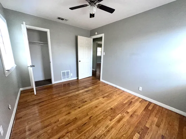 a view of empty room with wooden floor