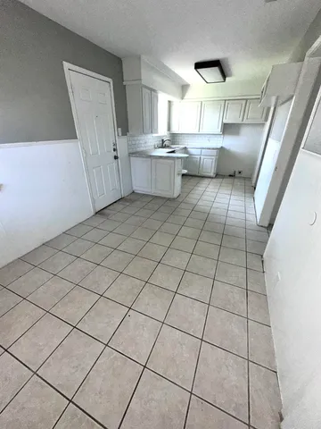 a kitchen with a sink a window and cabinets