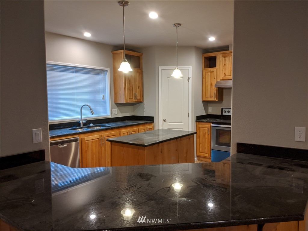 473 Harmon Road Chehalis, WA 98532 - Photo 7 of 15 a kitchen with stainless steel appliances granite countertop a sink a stove and a wooden floors