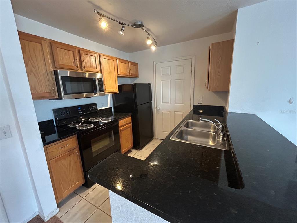 4850 51st Street West, Unit 8201 Bradenton, FL 34210 - Photo 3 of 14 a kitchen with a sink stove and microwave