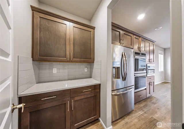 a kitchen with stainless steel appliances granite countertop a refrigerator and a stove