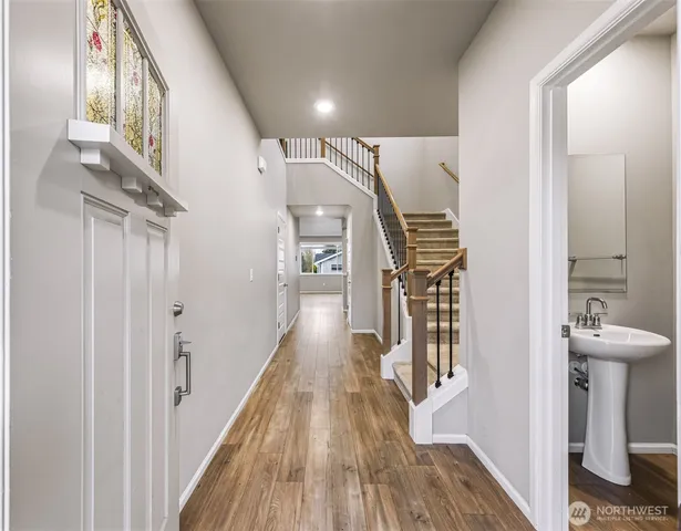 a view of a hallway with wooden floor and staircase