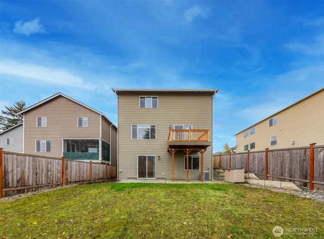 a view of a house with a yard and a large tree