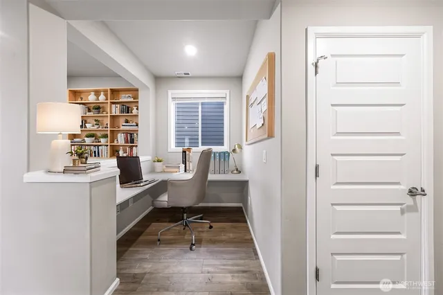 a view of a workspace with furniture and a window