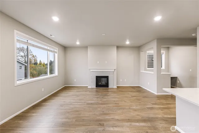 a view of a livingroom with a fireplace wooden floor and windows