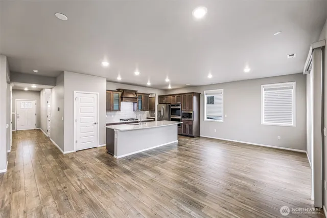 a view of kitchen with refrigerator stove and wooden floor