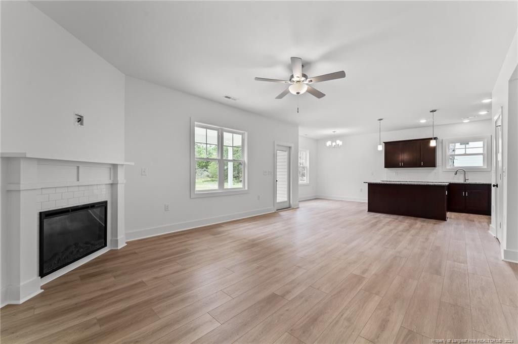 2902 Calloway (lot 1) Road Rockingham, NC 28379 - Photo 18 of 44 a view of a livingroom with a fireplace a ceiling fan a kitchen and a window