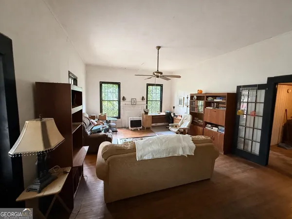 a living room with furniture a flat screen tv and a refrigerator