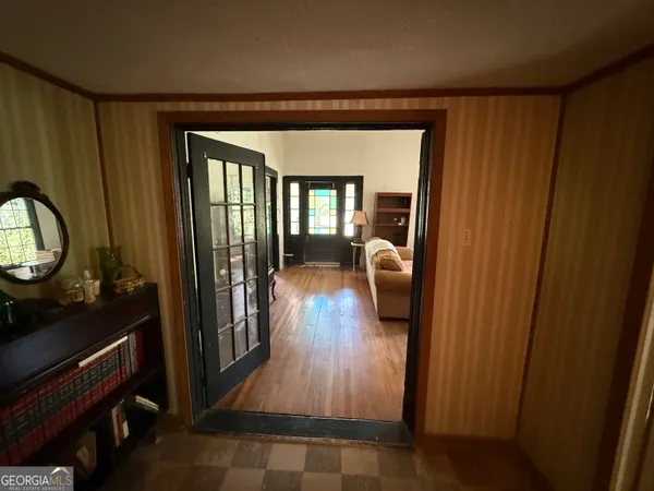a hallway with wooden floor windows a fireplace and cabinet
