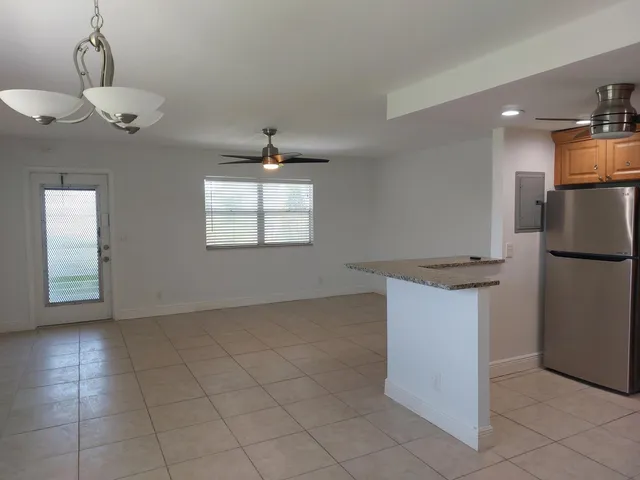 a view of a kitchen with a sink and dishwasher a refrigerator with white cabinets