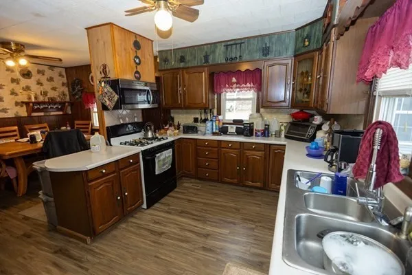 a kitchen with stainless steel appliances granite countertop a stove a sink dishwasher and cabinets with wooden floor