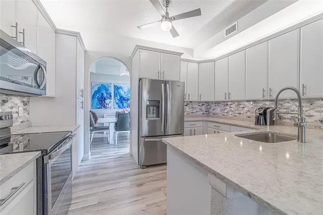 a kitchen with granite countertop a sink stainless steel appliances and counter space